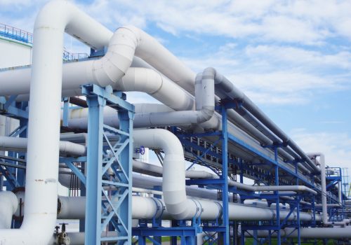 A closeup of industrial pipelines around a factor on a sunny day